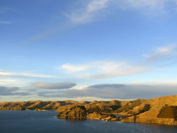 Scenic view of sea and mountains against sky