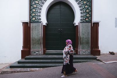 Full length of woman standing at entrance of building