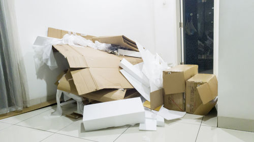 Broken cardboard boxes and polystyrene on tiled floor at home