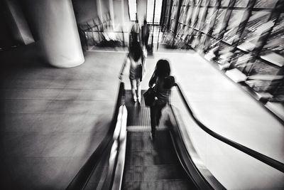 Woman standing on escalator