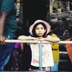 Portrait of girl leaning on railing at temple