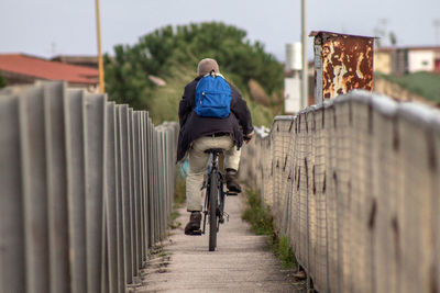 Rear view of man riding bicycle