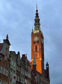 Low angle view of clock tower in city against sky