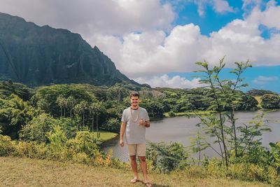 Portrait of man standing on mountain against lake