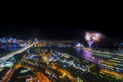 High angle view of firework display over buildings at night