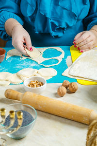 A jewish woman makes dough blanks gomentashi cookies with poppy seeds, traditional for the jewish