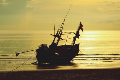 Fishing boat on sea against sky during sunset