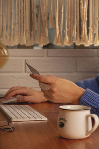 The woman makes online purchases at home on a computer.