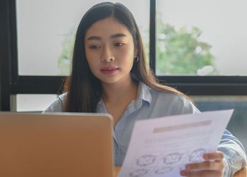 Portrait of a young woman using laptop