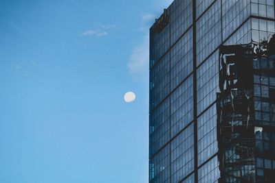 Low angle view of modern buildings against blue sky