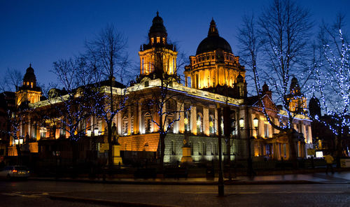 Illuminated building against sky at night