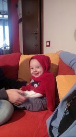 Boy sitting on sofa at home