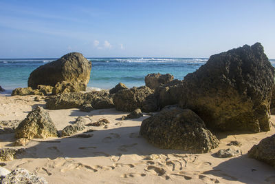 Rocks on beach against sky