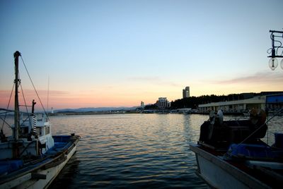 Boats in calm sea at sunset