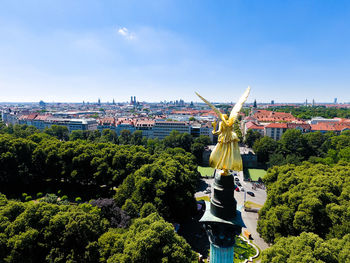 Statue in city against blue sky