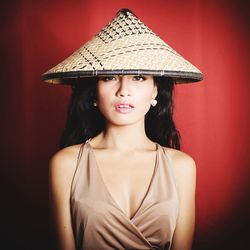 Portrait of beautiful young woman against red background