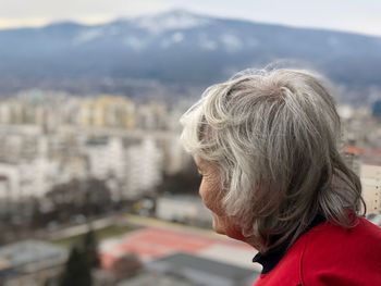 Side view of woman against city