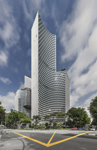 Road by buildings against sky in city