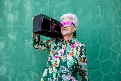 Portrait of woman standing against wall