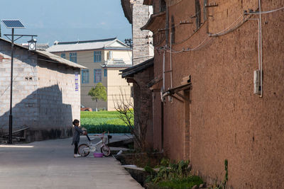 Man walking on street amidst buildings in city