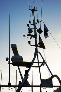 Low angle view of silhouette telephone pole against clear sky