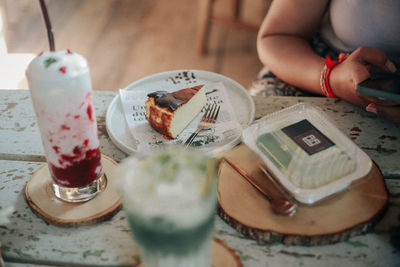 High angle view of hand holding glasses on table