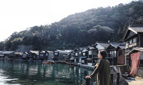 Woman standing by river in town