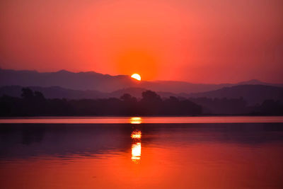 Scenic view of lake against romantic sky at sunset