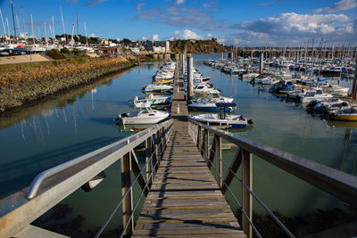 Boats moored at harbor against sky