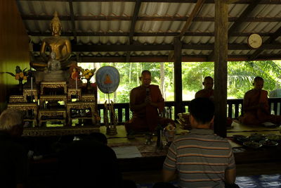 Rear view of people sitting in temple