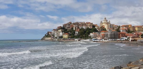 Scenic view of beach by buildings against sky