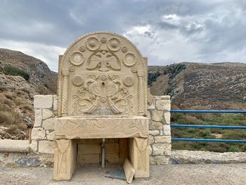 Old sculpture against sky