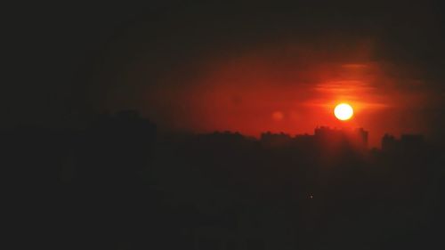 Silhouette landscape against orange sky