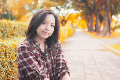 Portrait of smiling woman against trees