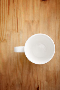 Directly above shot of empty coffee cup on wooden table