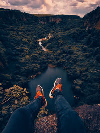 Low section of man on mountain against sky