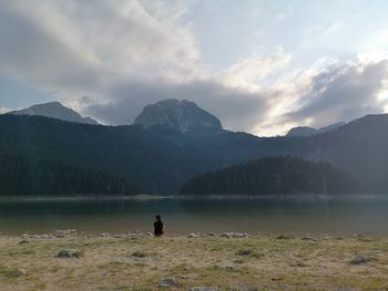 Rear view of man on lake against mountains