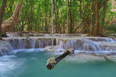 Empty wooden swing in beautiful nature with waterfall in forest at wang kan luang waterfall 