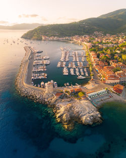 High angle view of city by sea against sky