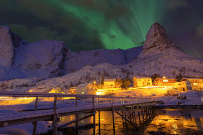 Illuminated buildings against sky at night norway