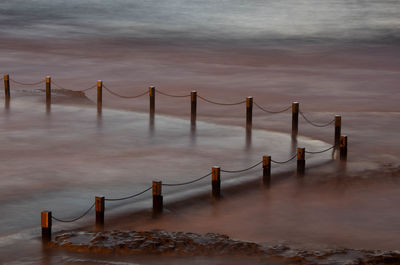 Wooden bridge over sea against sky