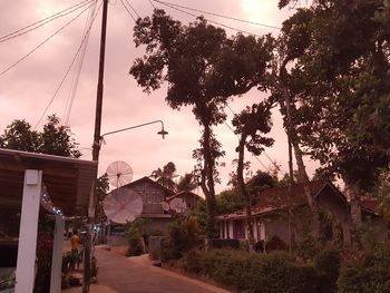 Street amidst buildings and trees against sky