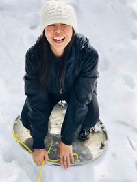 Full length of smiling woman in snow