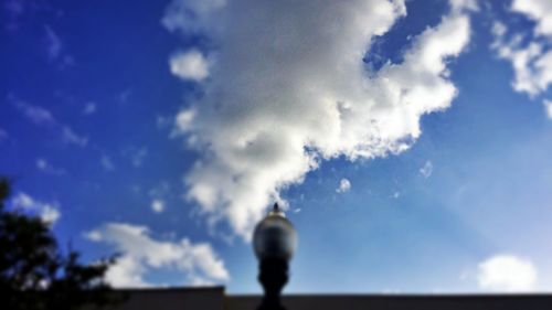 Low angle view of woman standing against cloudy sky