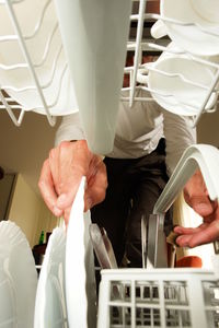 Midsection of man arranging plates in rack