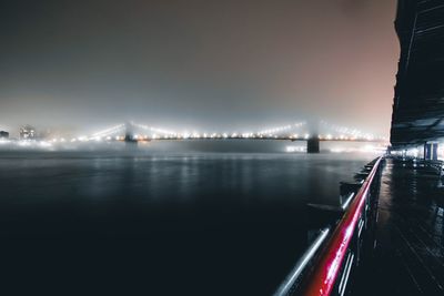 Light trails on bridge over river at night