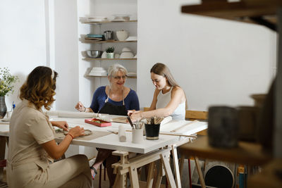 People working with clay in ceramic studio. pottery workshop in studio. adults learning to do