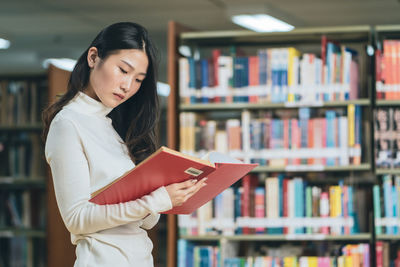 Young woman reading book at home