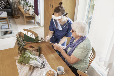 Home carer helping senior woman at home