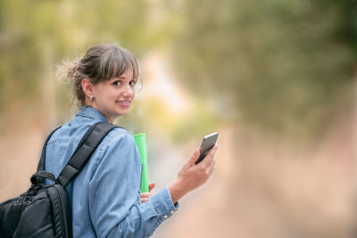 Portrait of young woman using smart phone outdoors